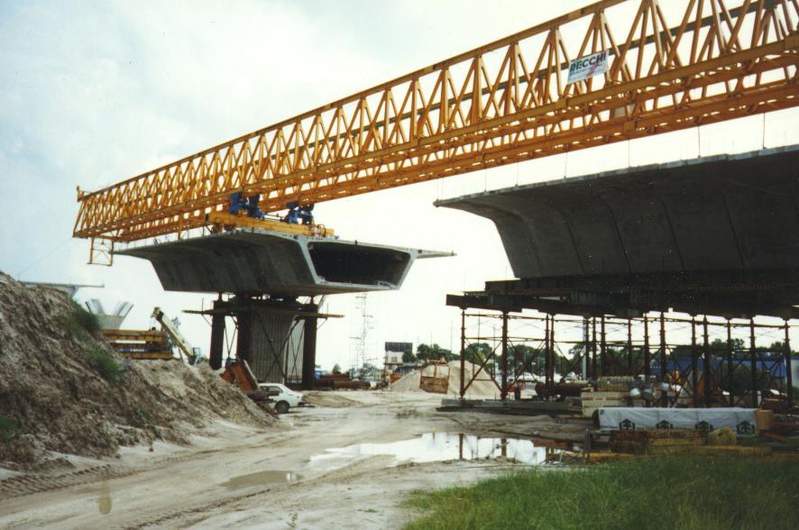 A metameric, or segmental, bridge under construction. You can see the balanced cantilever under construction with the gantry. A number of metameres, or segments, are positioned on either side of the pier (column on the left) forming the balanced cantilever. The metameres, or segments, are constructed on the ground using the short line casting/formset method. Once cured they are hoisted with the gantry into place.